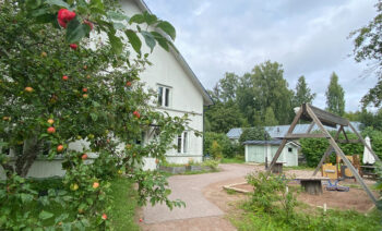 Stjärnsunds förskola med äppelträd i förgrunden och lekplats vid sidan av huset.