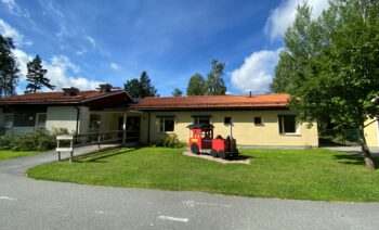 Förskolan Ekorren i Långshyttan, Gul byggnad med ett rött lektåg på gården.