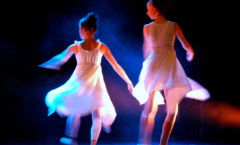 Barn som dansar på scen i strålkastarljus