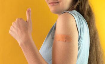 Glad tjej med plåster på armen, som fått vaccination