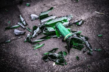 Krossade ölflaskor på marken