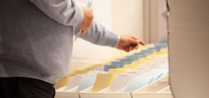 En man som står och väljer valsedlar.