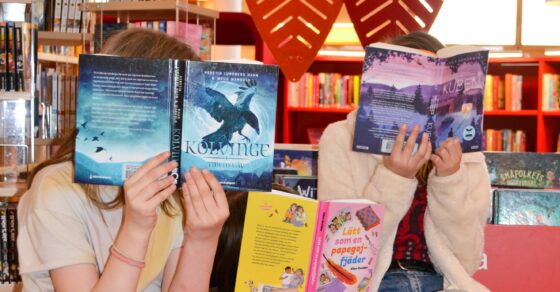 Tre barn med varsin bok som döljer ansiktet