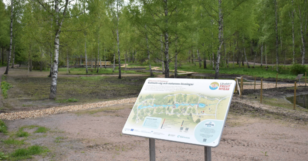 Informationsskylt och utblick över lärplats Prostmyran