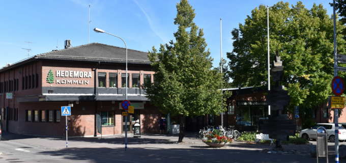 Kommunshusets entré med grönskande träd framför.