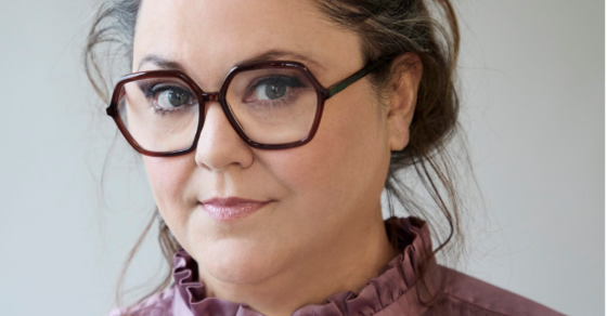 Kvinna med svarta glasögon och rosa tröja
